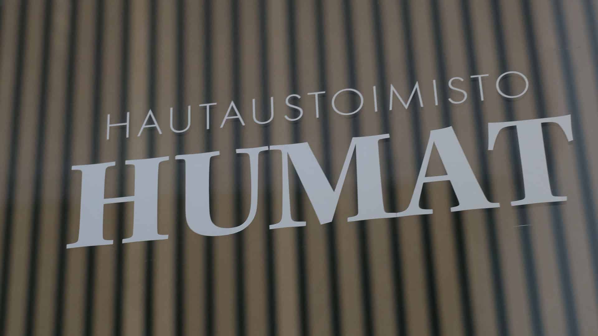 Hautaustoimisto Humatin kyltti toimiston puuseinällä